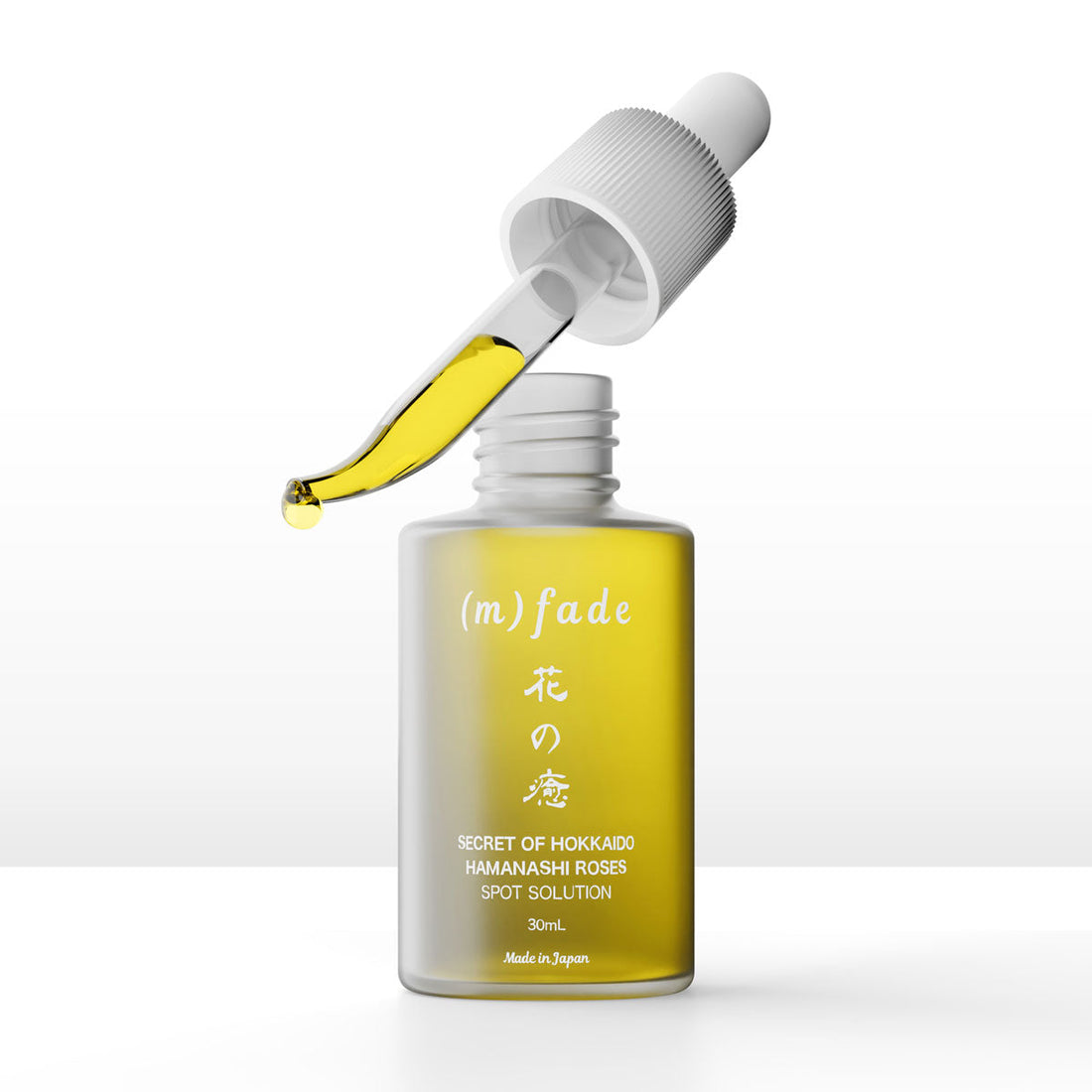 Open (m)fade 30ml bottle with a dropper holding yellow serum on a white background / 白色背景上的 (m)fade 30ml 開蓋瓶及盛有黃色精華的滴管